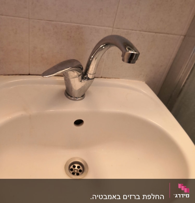 ברז כרום מותקן על כיור לבן בחדר אמבטיה